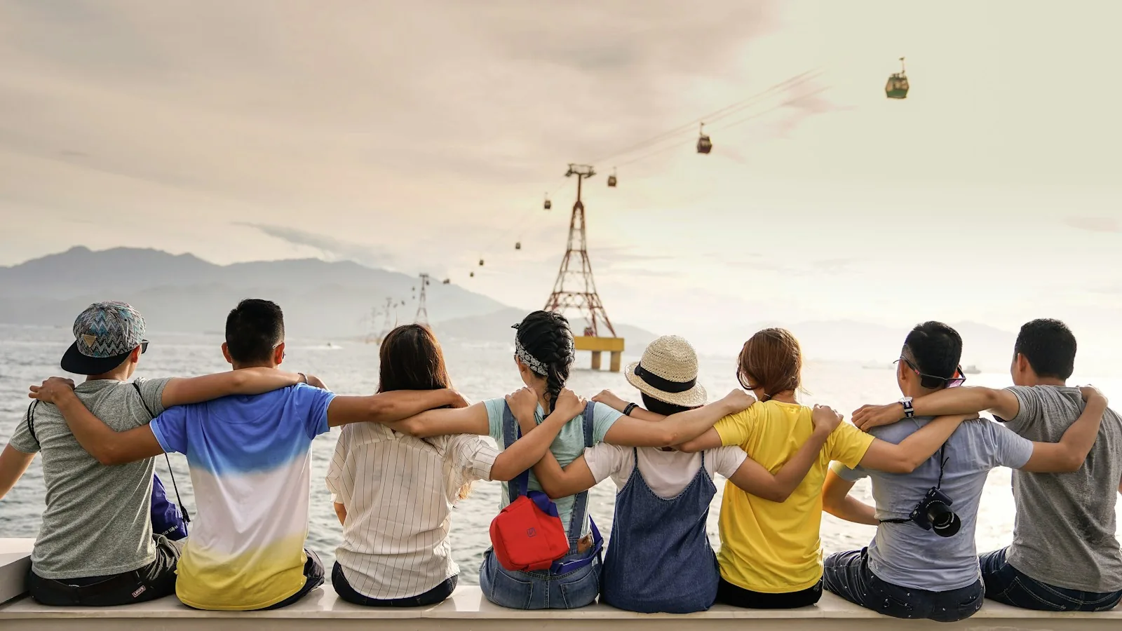 Group of friends sitting together outdoors, seen from behind
