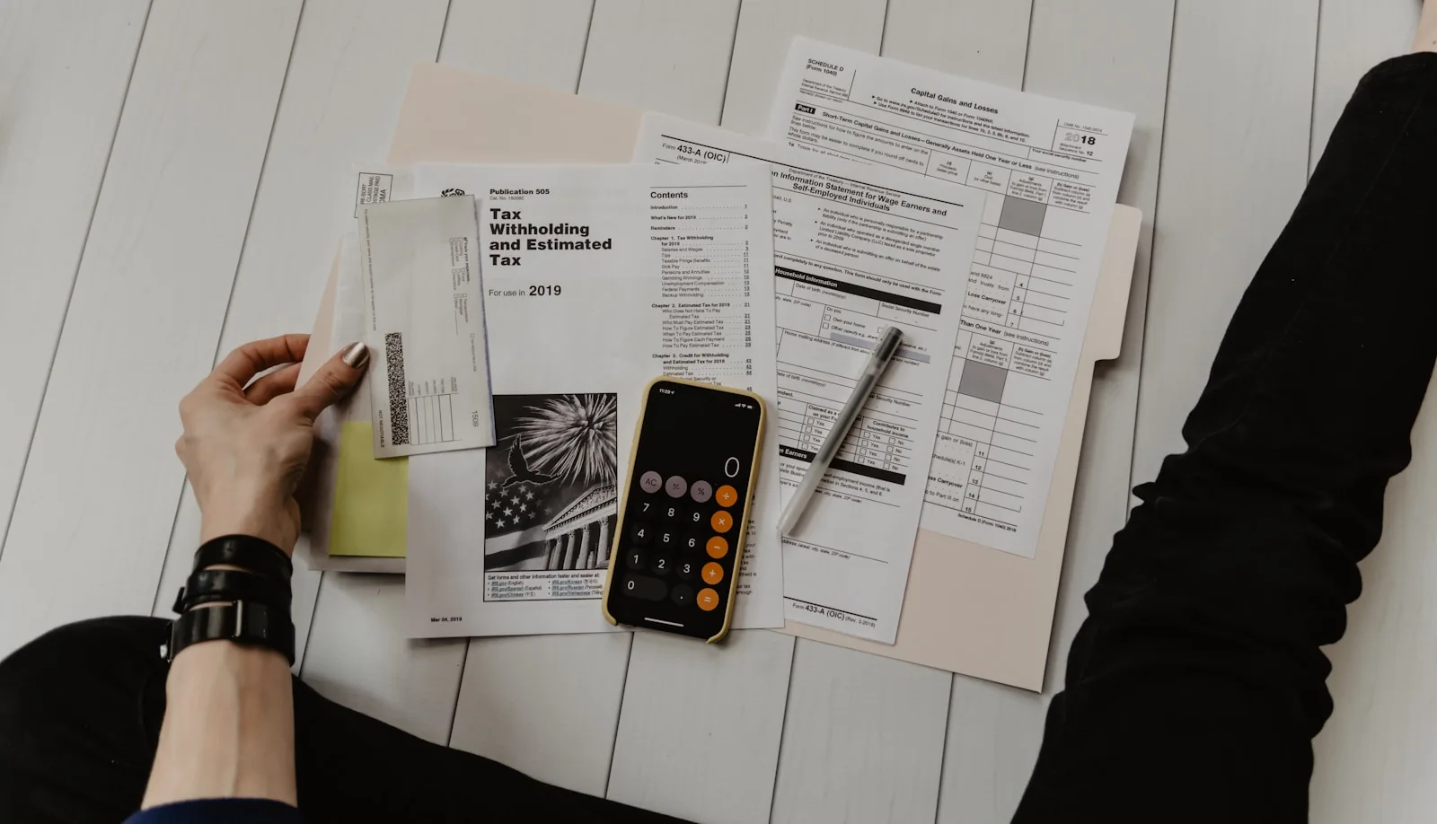 Person reviewing financial papers with a calculator