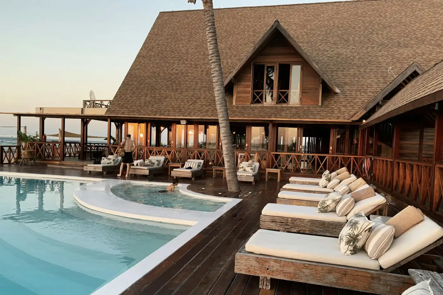 Resort pool deck with a wooden lodge