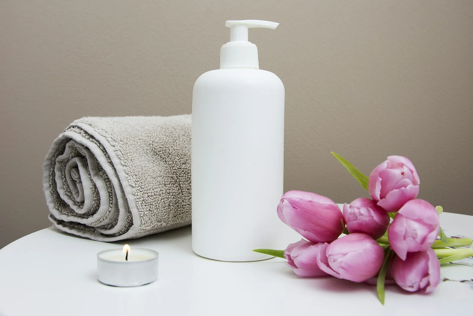 Spa towels with a candle and flowers