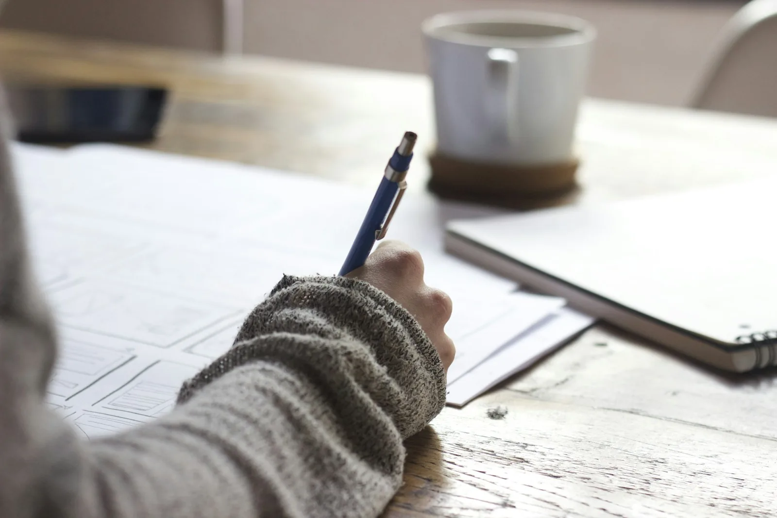 Person writing notes at a desk