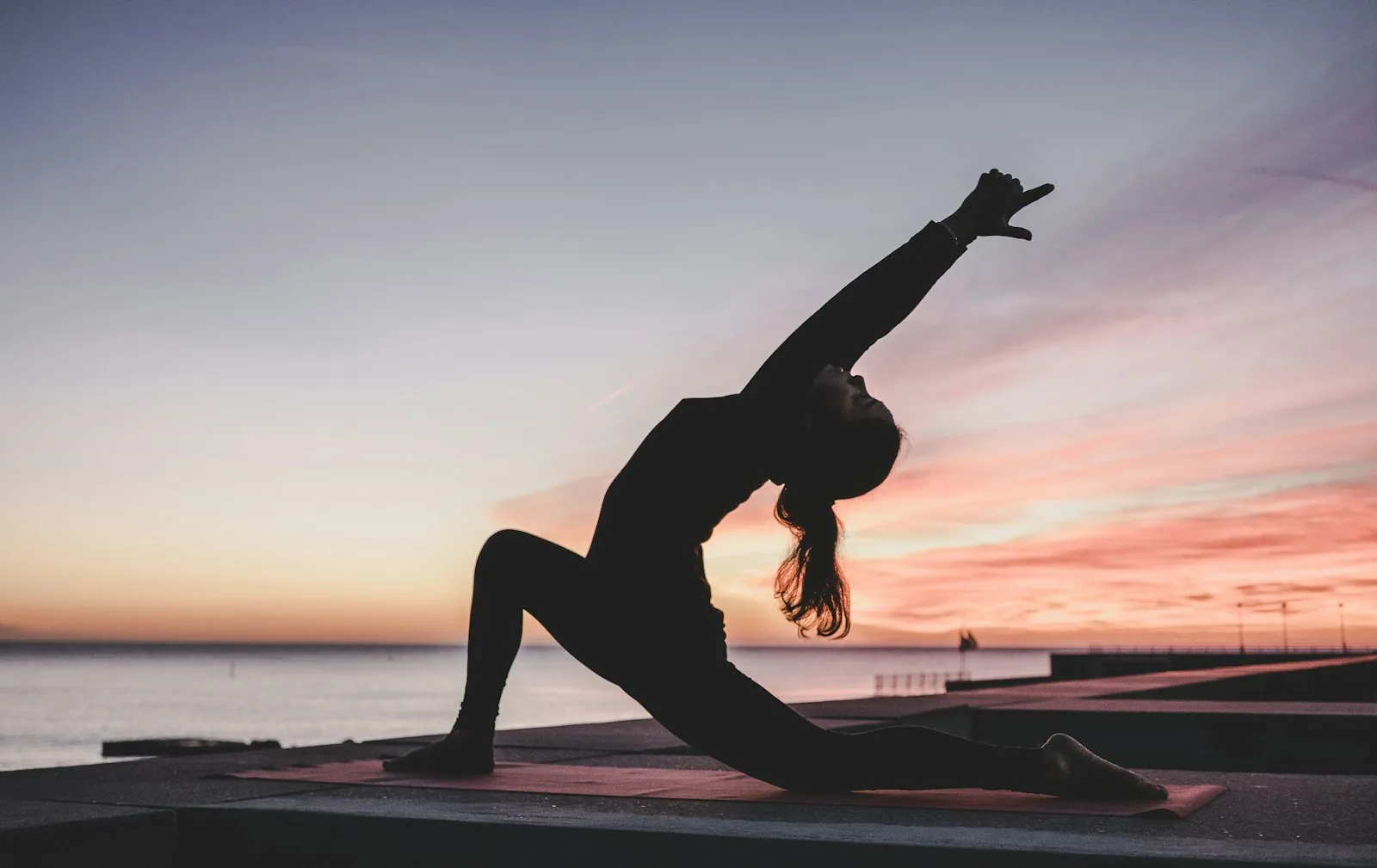 Person holding a yoga pose at sunset
